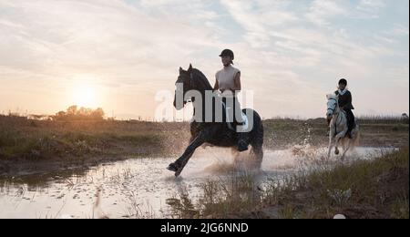 È sempre un buon giorno quando si è fuori a cavallo. Shot di due giovani donne a cavallo insieme. Foto Stock