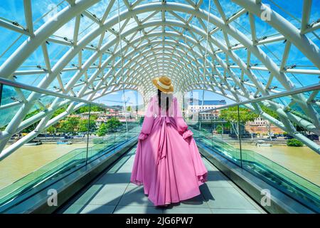 Turista a piedi sul ponte di pace a Tbilisi, Georgia. Foto Stock