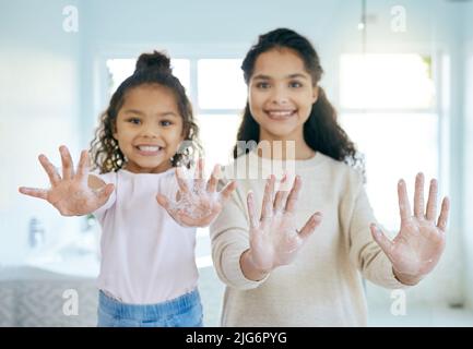 Abbiamo mani libere da germi. Shot di una bambina e sua madre lavando le mani in un bagno a casa. Foto Stock