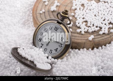 Retrò orologio da tasca su bianco palline di polistirene Foto Stock