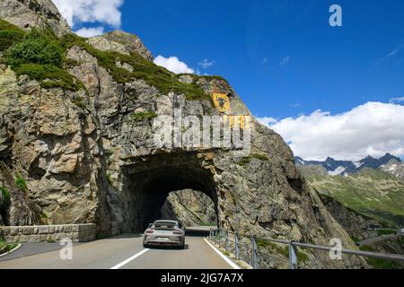 Supercar sport auto Porsche GT3 guida tunnel scolpito nella roccia, sopra dipinto stemma geografico del cantone Uri, Wassen, cantone Uri Foto Stock