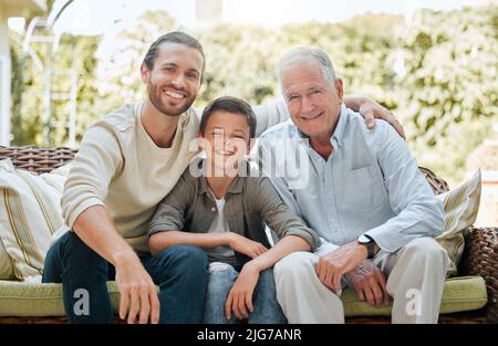 Sostenetevi con l'amore della famiglia. Fucilato di un uomo seduto fuori con il figlio e il padre anziano. Foto Stock