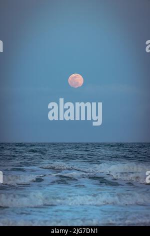 Luna piena dettagliata sulle onde scure dell'Oceano Atlantico in una notte limpida. Foto Stock