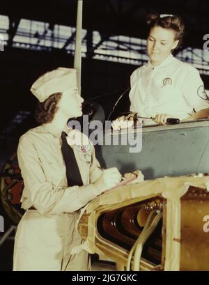 In precedenza era un'importante sociologia presso l'Università della California meridionale, la sig.ra Eloise J. Ellis (destra) ora "tiene 'em flyin'" alla base aerea navale, Corpus Christi, Texas. È un supervisore in servizio civile presso il reparto assemblaggio e riparazioni. E' suo compito mantenere morale tra le donne per aiutarli a risolvere i problemi di alloggio e altri problemi personali. Con lei è Jo Ann Whittington, un tirocinante DI NYA presso lo stabilimento. Foto Stock