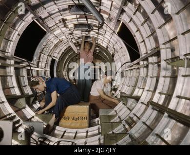 Le donne lavoratori installano infissi e assemblaggi ad una sezione di fusoliera di coda di un bombardiere B-17F alla Douglas Aircraft Company, Long Beach, Calif. Meglio conosciuto come "la Fortezza volante", il B-17F è un modello successivo del B-17 che si distingue in azione nel Pacifico del Sud, In Germania e altrove. Si tratta di un pesante bombardiere a lunga distanza, ad alta quota, con un equipaggio di sette a nove uomini, e con armamenti sufficienti per difendersi nelle missioni diurne. Foto Stock