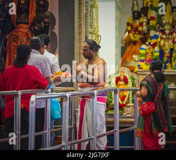 Sacerdote e fedele al Tempio Indu Sri Srinivasa Perumal o al Tempio Sri Perumal, Repubblica di Singapore Foto Stock
