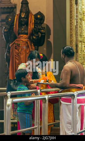 Sacerdote e fedele al Tempio Indu Sri Srinivasa Perumal o al Tempio Sri Perumal, Repubblica di Singapore Foto Stock