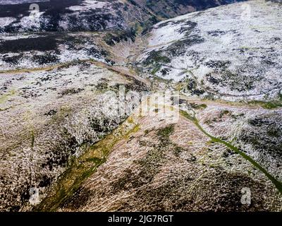 Una vista aerea drone di sentieri escursionistici coperti di neve nelle montagne dello Shropshire Foto Stock