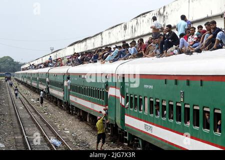 Le persone in casa aspettano il treno mentre viaggiano verso i loro villaggi, prima delle celebrazioni di Eid-al-Adha alla stazione ferroviaria di Dhaka, Bangladesh su J Foto Stock