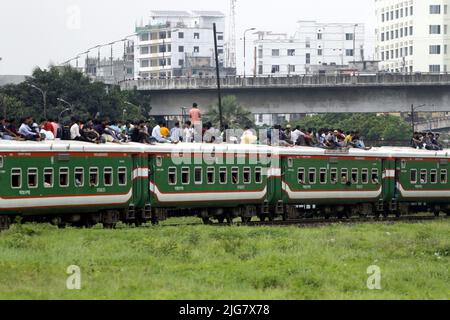 Le persone in casa aspettano il treno mentre viaggiano verso i loro villaggi, prima delle celebrazioni di Eid-al-Adha alla stazione ferroviaria di Dhaka, Bangladesh su J Foto Stock