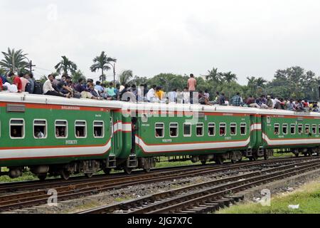 Le persone in casa aspettano il treno mentre viaggiano verso i loro villaggi, prima delle celebrazioni di Eid-al-Adha alla stazione ferroviaria di Dhaka, Bangladesh su J Foto Stock