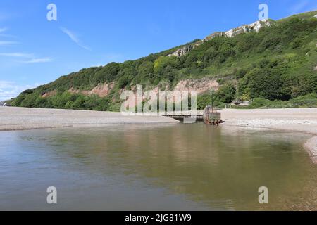 La foce del fiume Ax come incontra il mare a Axmouth nel Devon. È piuttosto stretto e diventa un torrente infuriante quando la marea cambia Foto Stock