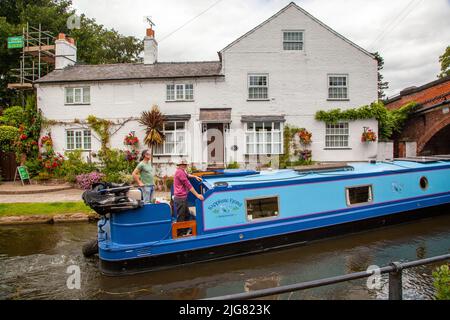 Barca a vela sul canale Bridgewater passando attraverso il villaggio di Cheshire di Lymm Foto Stock