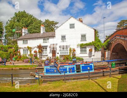 Barca a vela sul canale Bridgewater passando attraverso il villaggio di Cheshire di Lymm Foto Stock