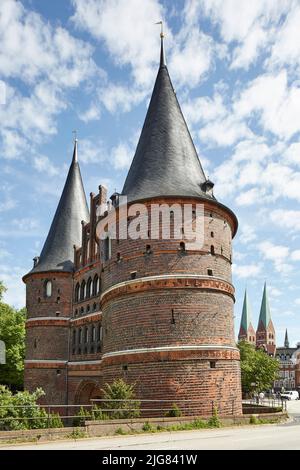 Germania, Schleswig-Holstein, Lübeck, Holstentor, sullo sfondo le torri della chiesa di San Marien Foto Stock