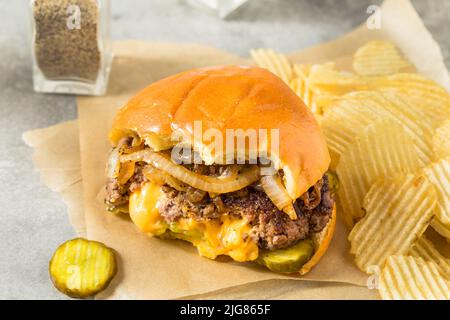 Cheeseburger Juicy Lucy fatto in casa con Cheddar e patatine Foto Stock