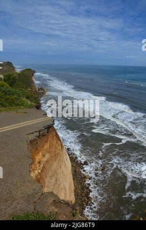 Una vista verticale della strada sulla scogliera che termina con l'oceano Foto Stock