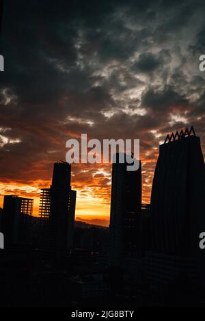 Un'immagine verticale di silhouette di edifici al tramonto Foto Stock