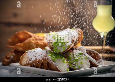 Cannoli siciliani appena sfornati spolverati con zucchero a velo da vicino Foto Stock