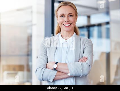 Le donne forti hanno stabilito lo standard per il successo. Ritratto di una donna d'affari matura e sicura che lavora in un ufficio moderno. Foto Stock