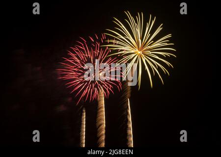 Fuochi d'artificio in primo piano che colorano il cielo notturno Foto Stock
