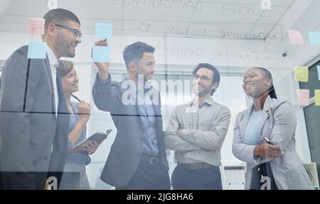 Registrare le nostre idee più brillanti. Shot di un team di persone aziendali che brainstorming idee insieme utilizzando appunti appiccicosi. Foto Stock