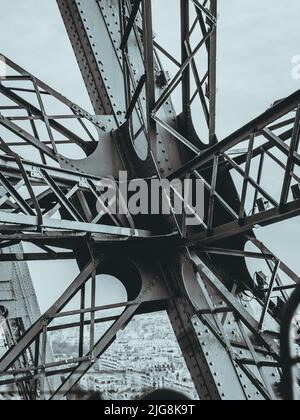 Una foto in scala di grigi ad angolo basso del fascio metallico della torre Eiffel Foto Stock