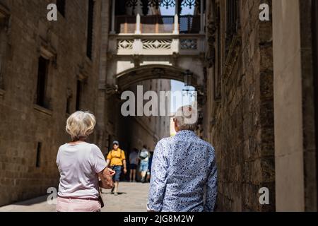 Barcellona, Spagna - 20 maggio 2022: Coppia anziana che cammina sul ponte Bispe nel quartiere Gotico di Barcellona, Catalogna (Spagna). Foto Stock