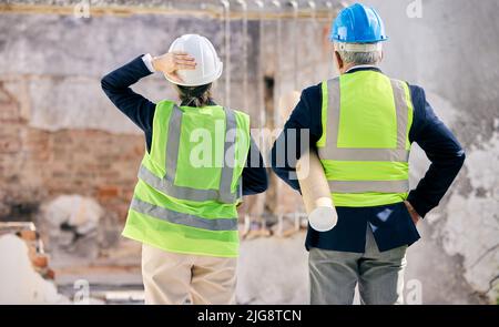 Sembra sempre impossibile fino a quando non viene fatto. Shot di ingegneri in piedi con progetti in un cantiere. Foto Stock