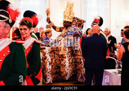 08 luglio 2022, Renania-Palatinato, Bad Dürkheim: Céphas Bansah, re africano residente in Renania-Palatinato, viene trasportato nella sala da ballo su un palanquin alla cerimonia di premiazione 'Golden Winemaker' della società di carnevale 'Gerkemer Grawler' nel Kurhaus. Si distinguono personalità di spicco, che si sono rese meritorie in aree socialmente importanti. Bansah vive a Ludwigshafen dal 1970 e si preoccupa di più di 300.000 persone dalla tribù Ewe in Ghana da lontano. Foto: Uwe Anspach/dpa Foto Stock