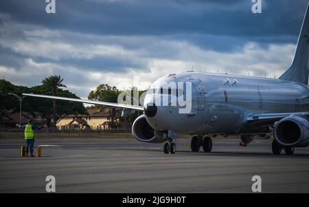 220706-N-EE352-2002 PEARL HARBOR (6 luglio 2022) un aviatore dirige un aereo della Royal Australian Air Force P-8A Poseidon Maritime Patrol sulla flightline alla base dell'aeronautica di Hickam, Hawaii, durante il Rim of the Pacific (RIMPAC) 2022. Ventisei nazioni, 38 navi, quattro sottomarini, più di 170 aerei e 25.000 persone partecipano a RIMPAC dal 29 giugno al 4 agosto nelle isole Hawaiane e nella California meridionale. Il più grande esercizio marittimo internazionale del mondo, RIMPAC offre un'opportunità di formazione unica, promuovendo e sostenendo le relazioni di cooperazione tra partecipate Foto Stock