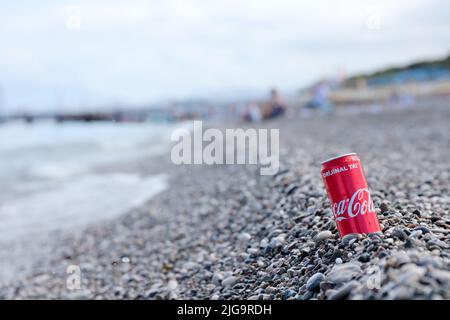 ANTALYA, TURCHIA - 18 MAGGIO 2021: L'originale lattina rossa Coca Cola si trova su piccole pietre di ciottoli rotonde vicino al mare. Coca-cola sulle pietre della spiaggia turca Foto Stock