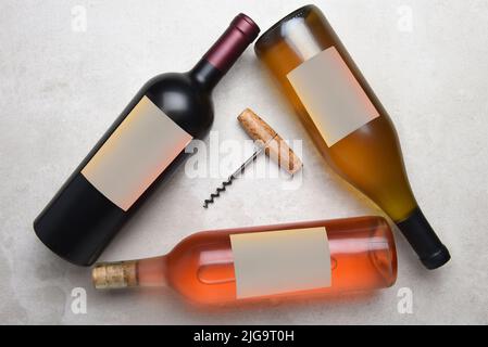 Cabernet, Rose, Chardonnay: Vista dall'alto di un gruppo di tre bottiglie diverse con etichette bianche disposte a triangolo con cavatappi al centro Foto Stock