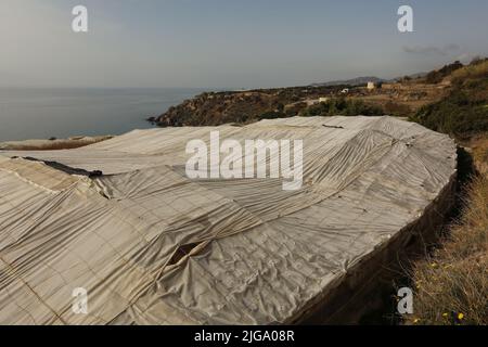 Serra di plastica bianca con struttura a vista sul mare e sulle montagne Foto Stock