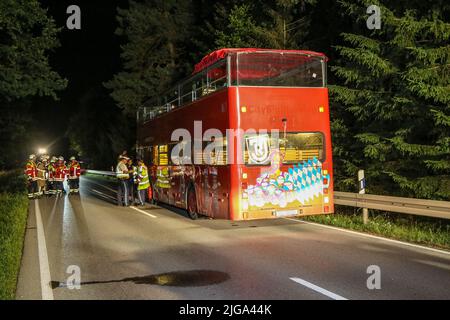 Steinberg am See, Germania. 09th luglio 2022. I soccorritori si trovano accanto a un autobus a due piani. Una celebrazione sul ponte di un autobus open-top si è conclusa con gravi lesioni per un uomo di 27 anni il venerdì sera. L'ospite del partito si alzò dal suo posto durante il giro sull'autobus a due piani e si schiantò nel ponte autostradale basso vicino ad un sottopasso a Steinberg am See (distretto di Schwandorf), secondo la polizia. Credit: Bauernfeind/vifogra/dpa/Alamy Live News Foto Stock