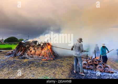 villaggio tradizionale in ceramica, gli artigiani bruciano prodotti, che sono fatti con le loro mani in modo tradizionale con legno e paglia di riso all'aperto Foto Stock