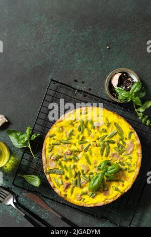 Сlassic quiche Lorraine torta con tonno, fagioli verdi e formaggio morbido. Quiche crude con uova, pesce e verdure. Chetogenico mediterraneo sano d Foto Stock