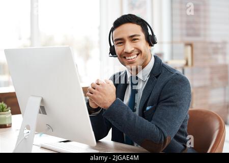 L'agente del call center più cordiale. Un giovane agente del call center maschile che lavora in ufficio. Foto Stock