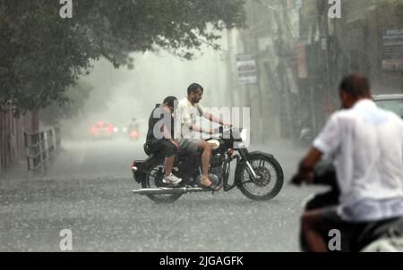 Jammu, Kashmir controllato dall'India. 8th luglio 2022. La gente guida una motocicletta in un downpour in Jammu, la capitale invernale del Kashmir indiano-controllato, 8 luglio 2022. Credit: Str/Xinhua/Alamy Live News Foto Stock