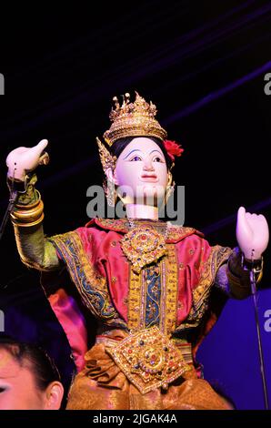 Il burattinaio professionista thailandese o il padrone del burattini manipolano suonare il giocattolo antico del burattini o la marionetta antica sul palco mostrano la gente in Nig Foto Stock