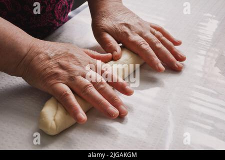 Primo piano della preparazione femminile delle mani di pasta per Baklava, Baklava fatta in casa con noci, ricetta tradizionale turca di vecchio stile, pasticceria alimentare Foto Stock