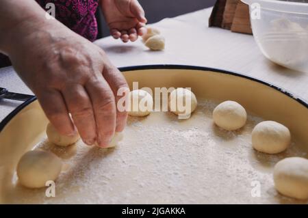 Primo piano della preparazione femminile delle mani di pasta per Baklava, Baklava fatta in casa con noci, ricetta tradizionale turca di vecchio stile, pasticceria alimentare Foto Stock