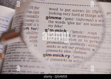 La definizione della parola gimmick in un dizionario, in lente d'ingrandimento, traduttore e concetto di lingua Foto Stock