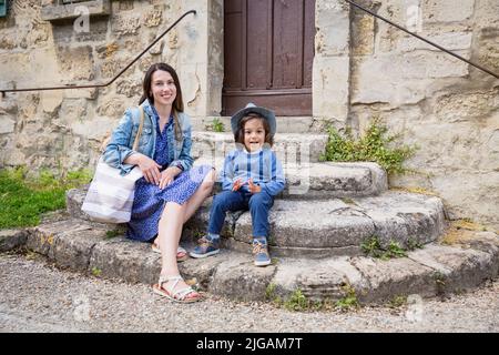 Madre e piccolo bel bambino ragazzo seduto su scale di pietra antica Foto Stock