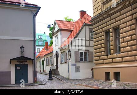 Riga, Lettonia - 10 settembre 2013: Via Klostera, una piccola strada accogliente con un pavimento di ciottoli nel centro storico della città. Foto Stock