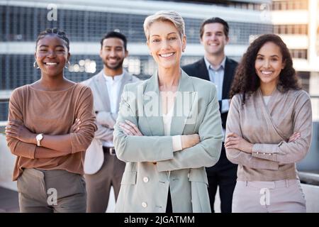 Unisciti a noi mentre lavoriamo per il successo. Un gruppo di uomini d'affari che si riuniscono in città con le braccia ripiegate. Foto Stock