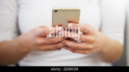 Al dentista per un controllo. Una donna irriconoscibile usando il suo telefono. Foto Stock