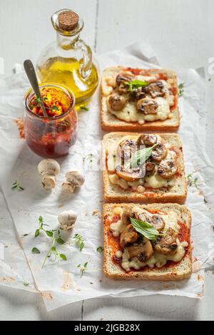 Toast gustosi e croccanti a base di funghi, pepe e formaggio. Toast vegetariani con funghi e formaggio. Foto Stock