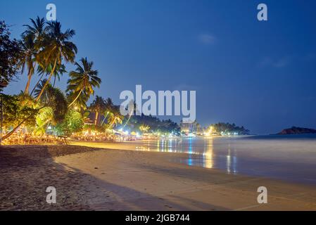 Caffè, ristoranti e nightclub sulla riva dell'Oceano Indiano in Sri Lanka di notte Foto Stock