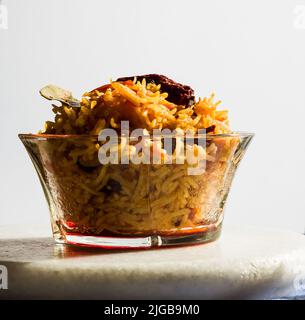 Vista dall'alto della ciotola di riso di pomodoro o di Tamatar Pilaf o Pulao, piatto vegetariano dell'India del Sud su sfondo bianco.Copy Space.Front view, primo piano Foto Stock